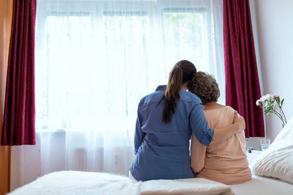 Family member reviews a care plan with an older resident at a quiet assisted living table.