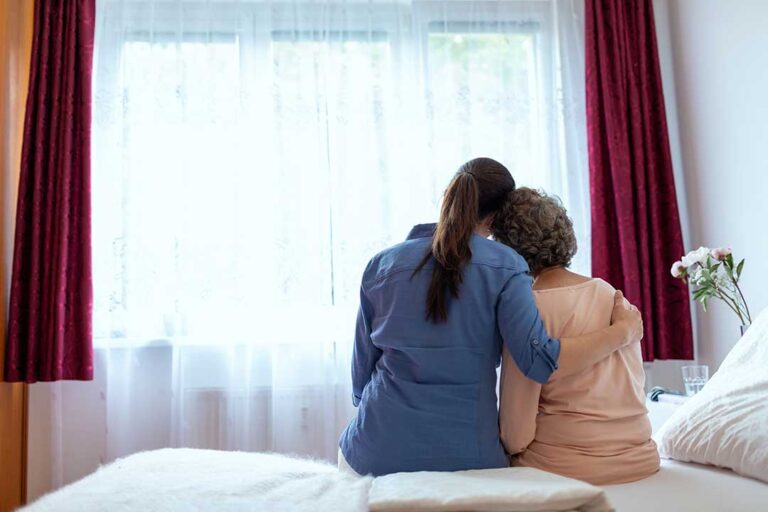 Family member reviews a care plan with an older resident at a quiet assisted living table.